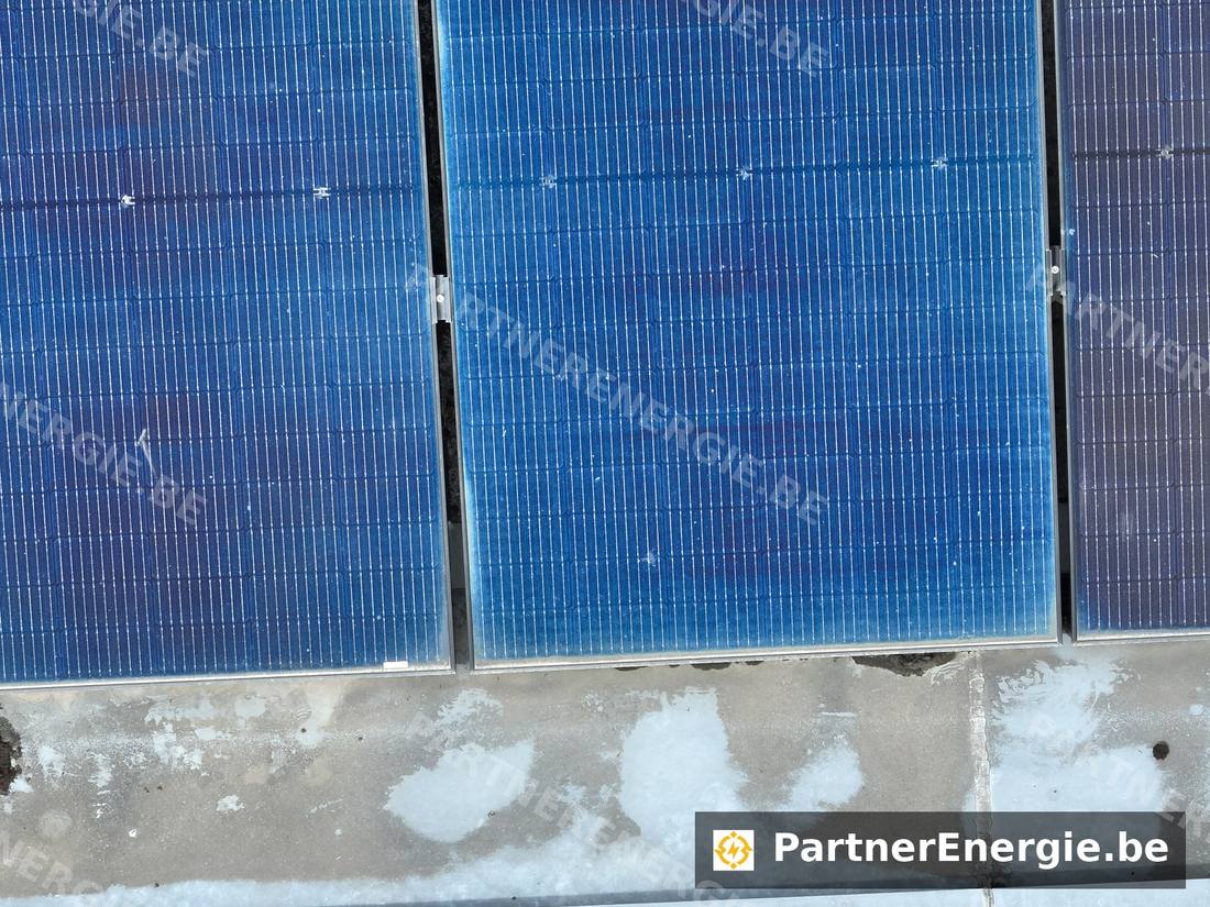 Bord d'un champ photovoltaïque sur toiture plate enneigée — Partner Energie