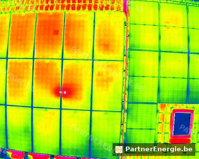 Vue thermique aérienne d'une toiture solaire, hot-spot intense visible en rouge et magenta