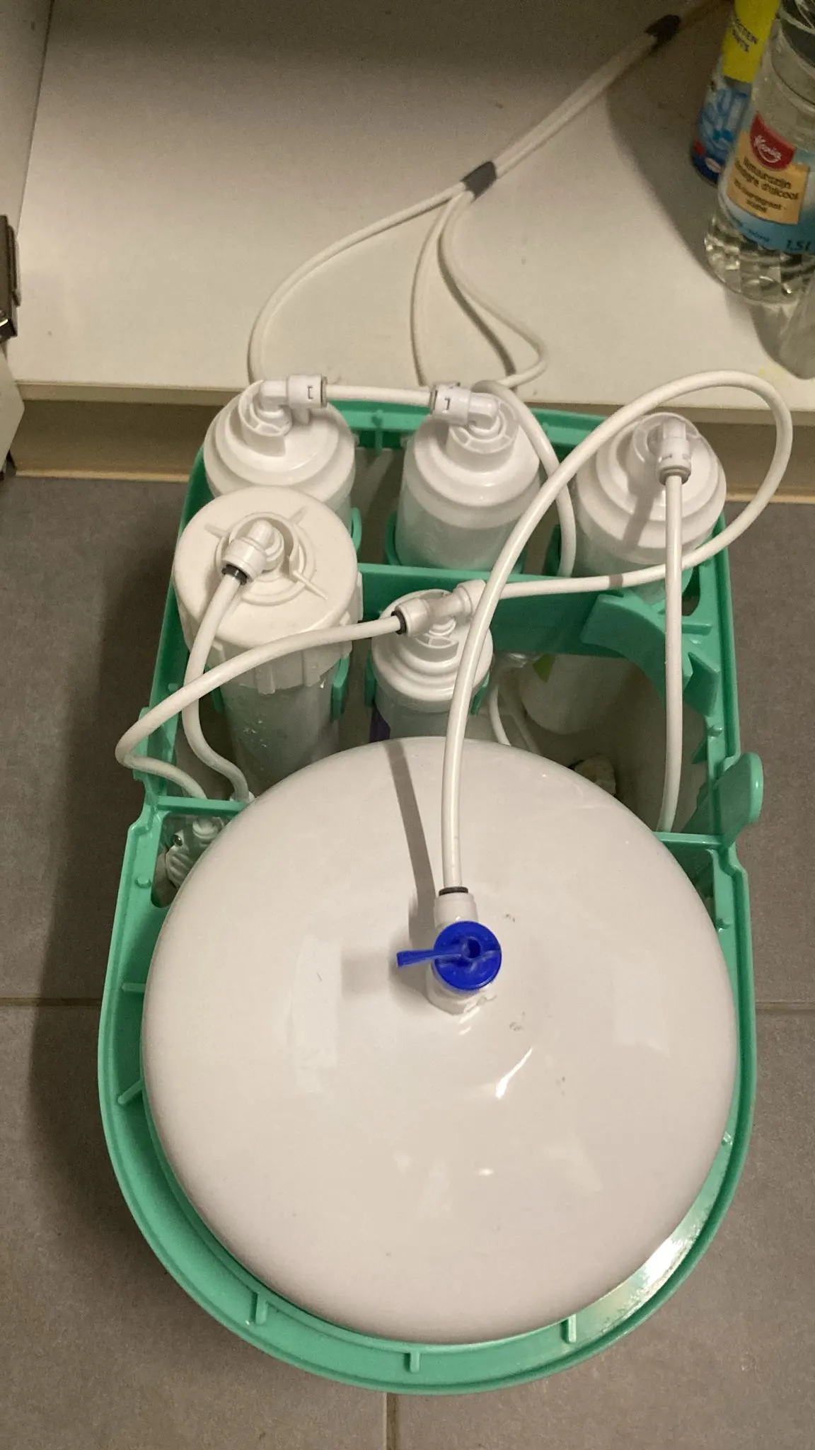 Technicien effectuant un test de dureté de l'eau au robinet d'une cuisine