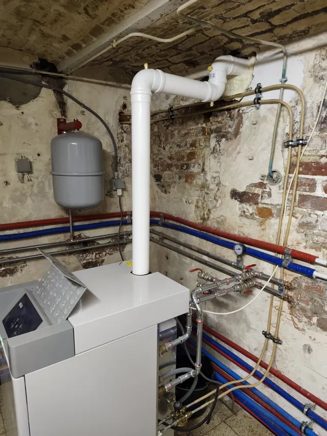 Échangeur d'une chaudière à condensation démonté montrant des dépôts de boue