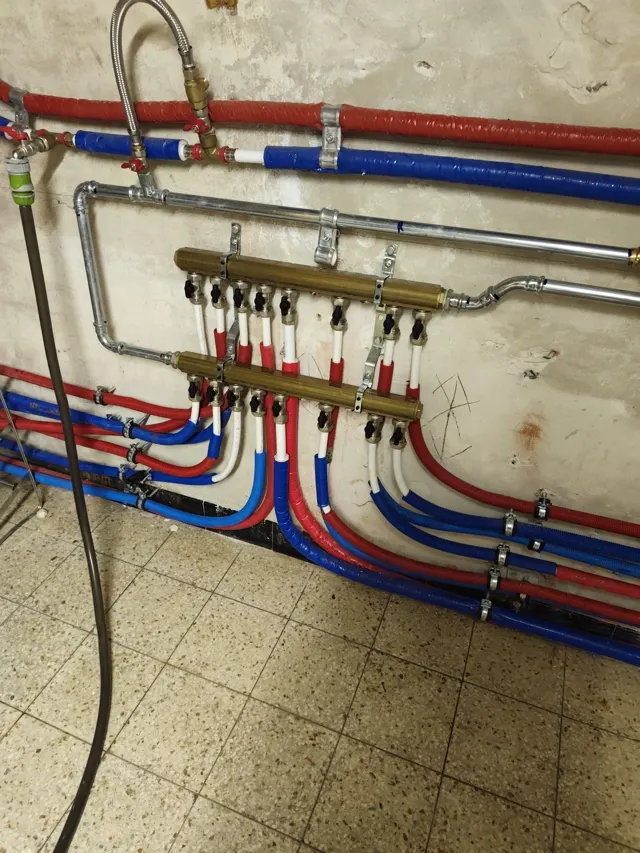 Purge d'un radiateur de chauffage central avec une clé carrée et un chiffon