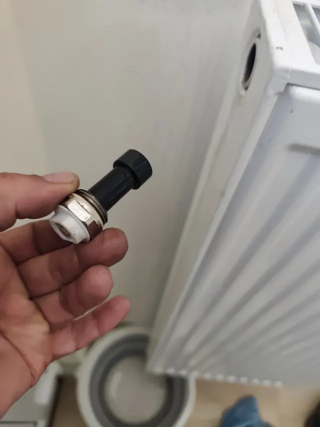 Technicien raccordant une machine de désembouage sur un circuit de chauffage central