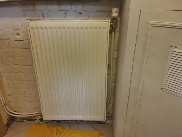 Radiateur en fonte d'une maison ancienne du Borinage, eau noire à la purge