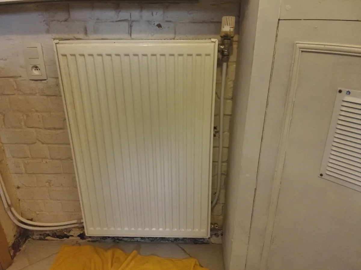 Radiateur en fonte d'une maison ancienne du Borinage, eau noire à la purge