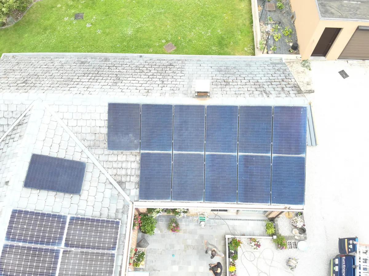 Écran de suivi de production photovoltaïque comparé à un contrat de garantie sur un bureau