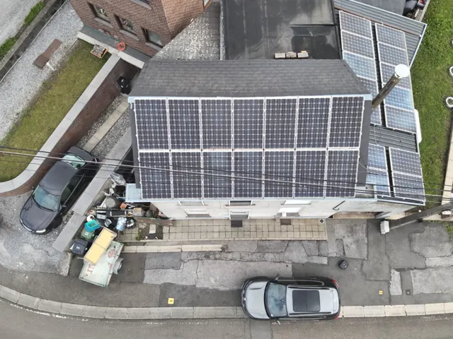Télépilote certifié A2 préparant un drone avant une inspection thermique en zone résidentielle