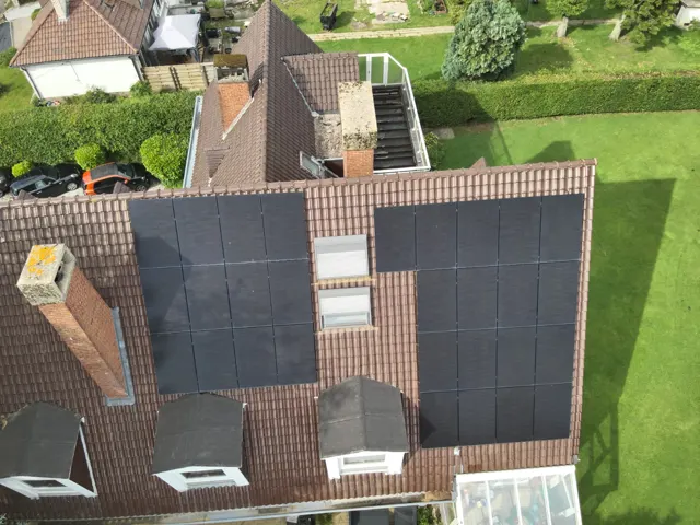 Technicien contrôlant visuellement une rangée de panneaux solaires lors d'un entretien annuel