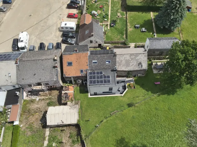 Courbe de production solaire sur une tablette à côté d'un onduleur dans une maison