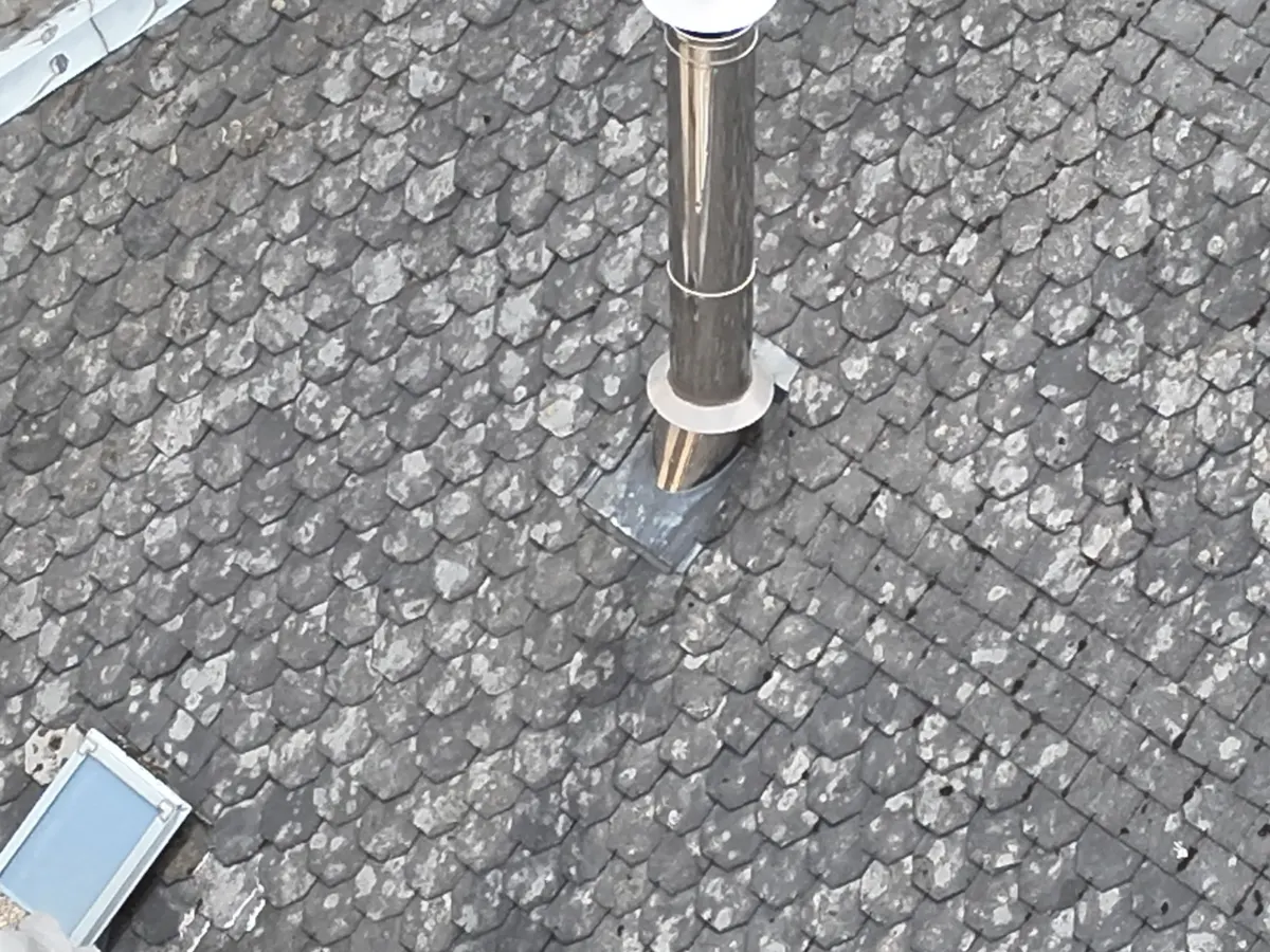 Particulier nettoyant des panneaux solaires avec une perche et une brosse douce depuis le sol