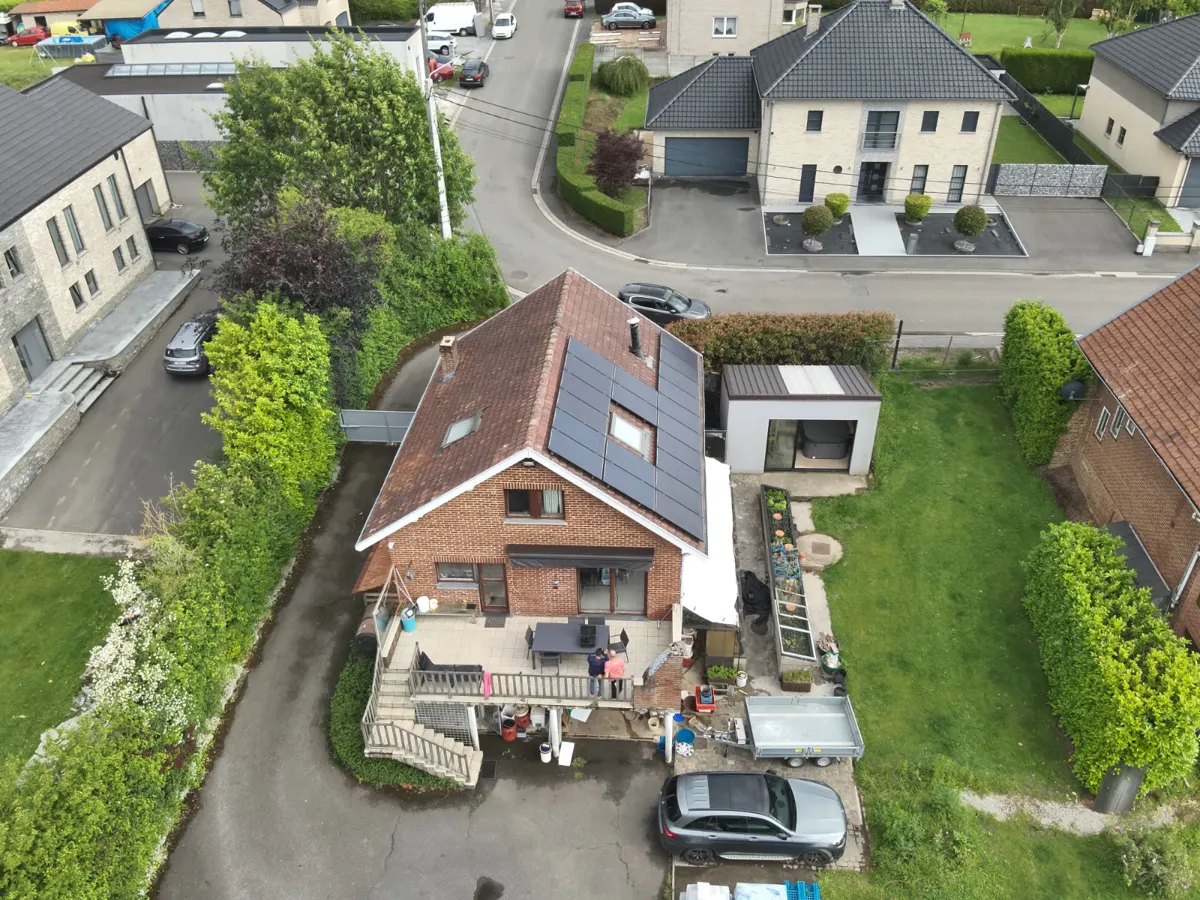 Technicien mesurant la tension d'une chaîne de panneaux solaires avec un multimètre