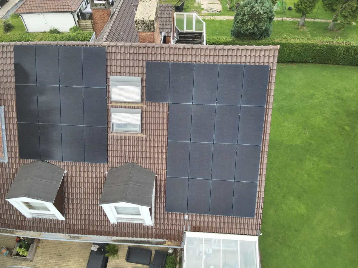 Micro-onduleur fixé sous un panneau solaire comparé à un onduleur central de garage